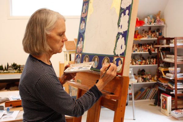 Kristi Ryba, the 2020 South Arts State Fellow from South Carolina, seated and painting in her studio.