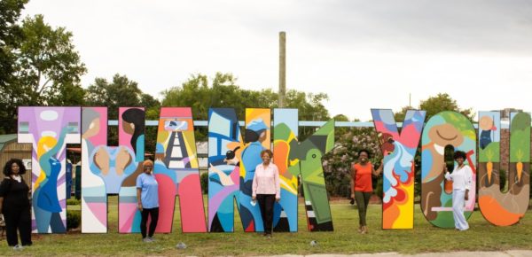 Group picture with big, colorful cutout letters spelling "thank you."