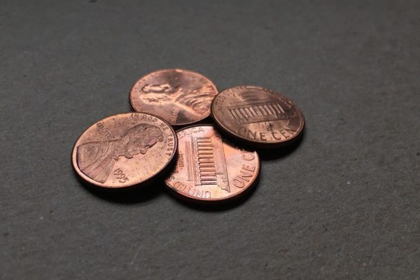 Four pennies on a dark gray background