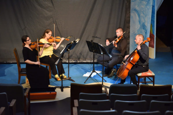 A Summerville Orchestra string quarter performs on an indoor stage.