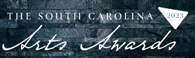 Graphic with white copy on a dark blue background overlaid on granite blocks. The white text reads South Carolina Arts Awards 2023.