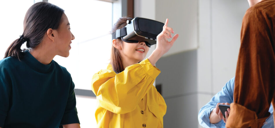 Asian woman with virtual reality glasses headset touching air during the VR experience, Young asia business team developers meeting with virtual reality simulator application test at creative office,