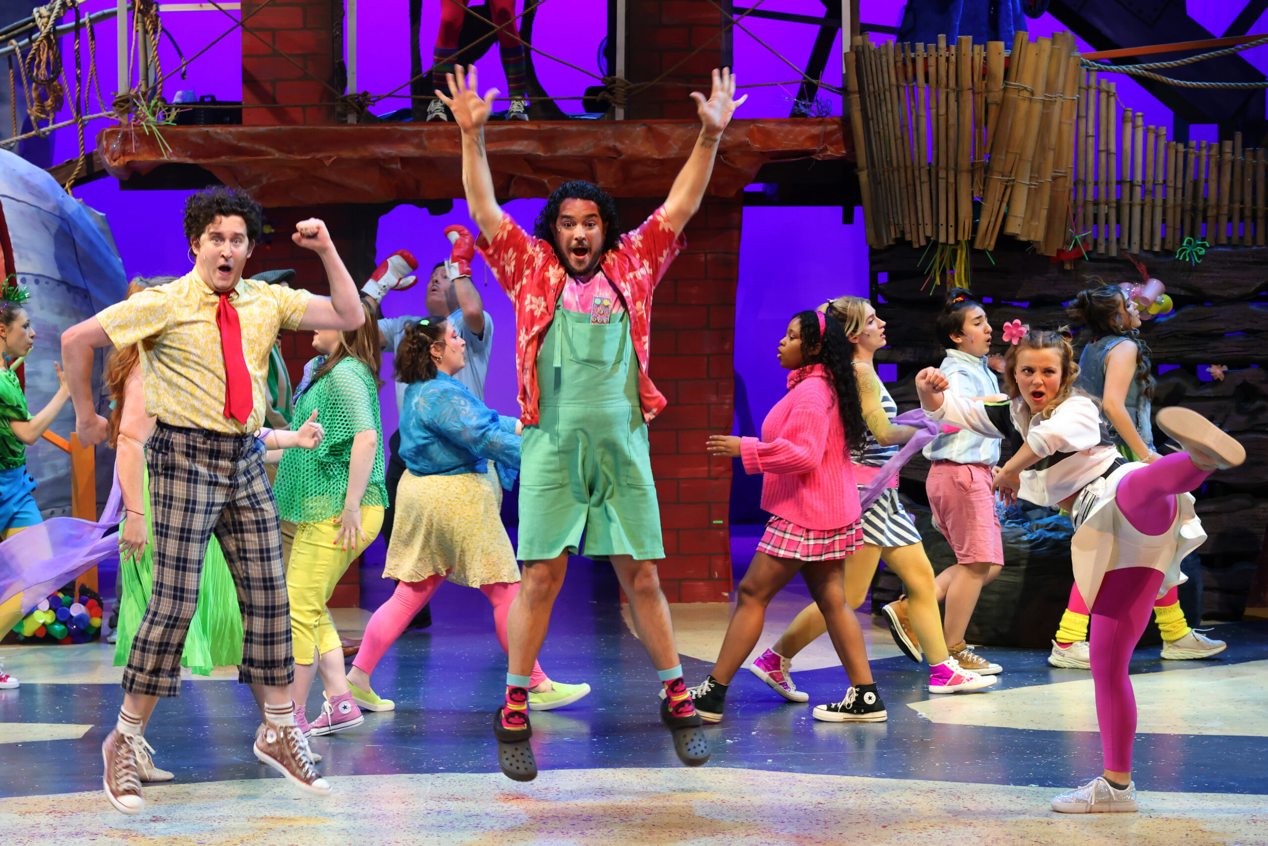 youths in colorful costumes perform a scene from the SpongeBob musical
