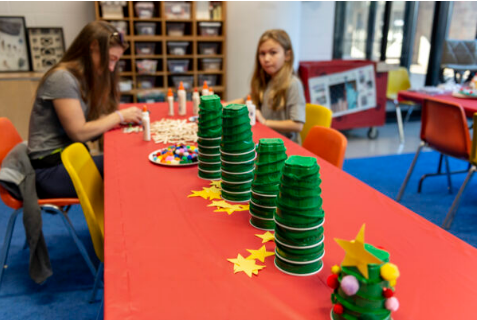 two youths working at a table with craft supplies