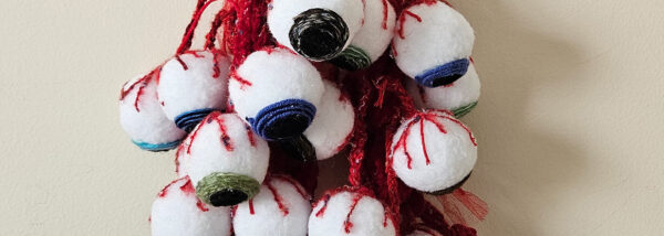 fabric artwork depicts white eyeballs hanging by red blood vessels