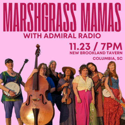 a group of casually dressed women posing for a photo with stringed instruments