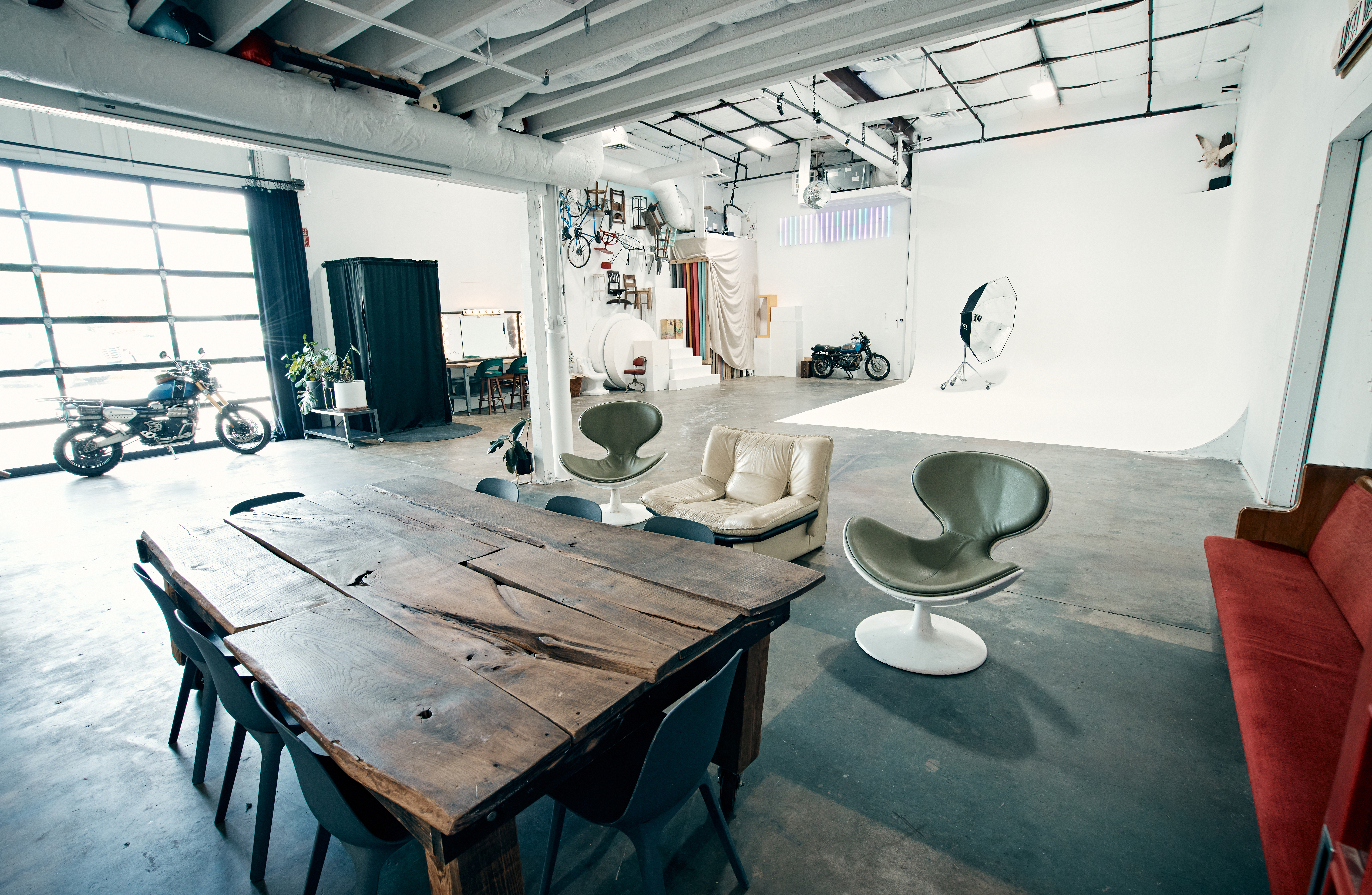Open photography studio with concrete floor, high ceilings and white walls.