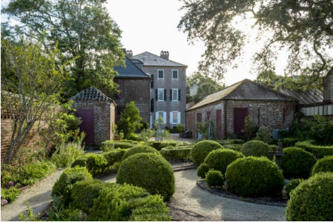A Georgian-style brick house from the 1740s, with a kitchen building and formal gardens.