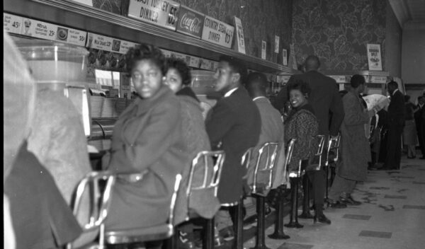 A black and white photo of Black students sitting at a lunch counter in 1961 South Carolina.