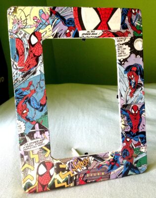 A tabletop picture frame covered with Spider-Man comic book images.