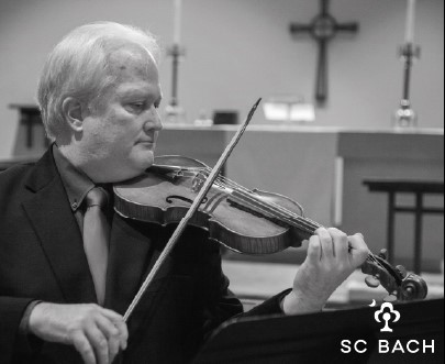 A man in a dark suit plays the violin.