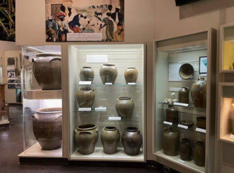 Clay pots of varying sizes, displayed in museum cases.