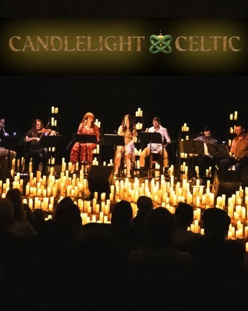 Performers seated behind music stands on a stage, surrounded by a large number of lit candles.