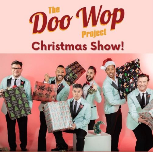 Five men dressed as a mid-20th century American singing group hold wrapped Christmas gifts.