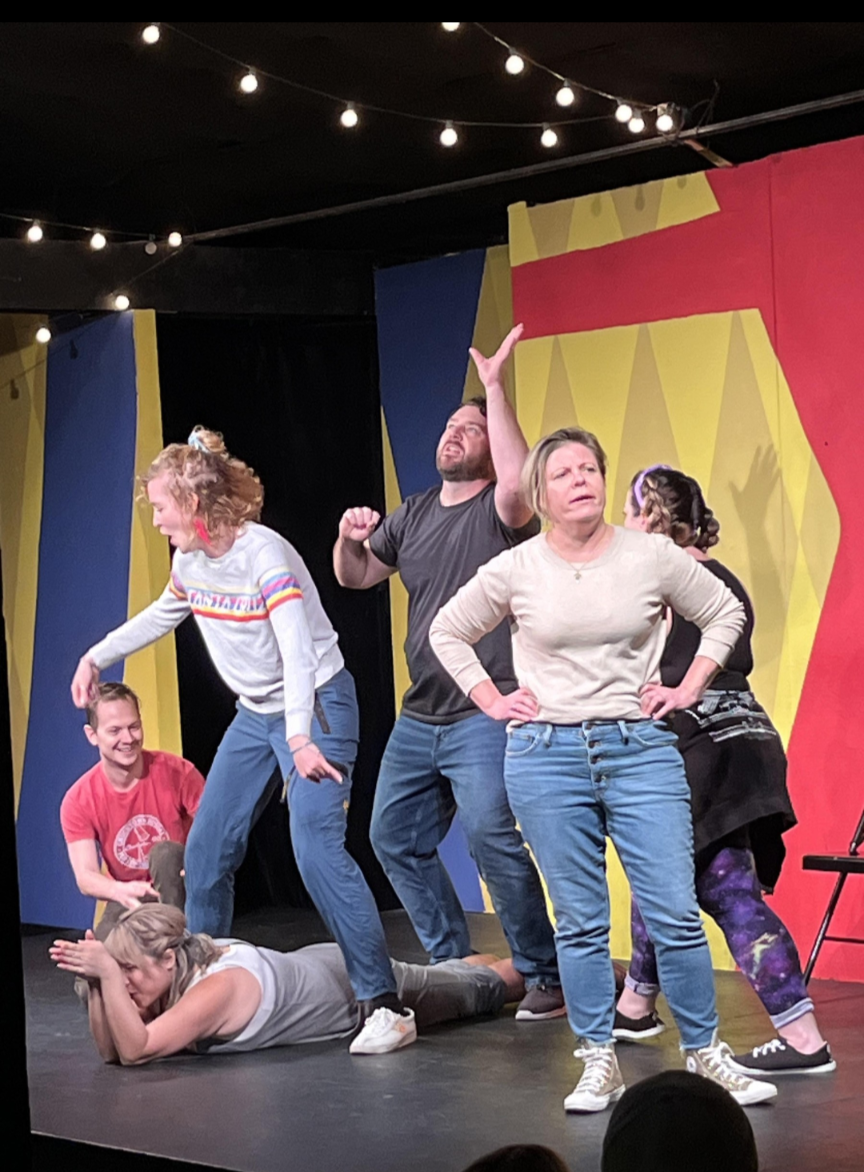 6 actors onstage in an improvisational scene.