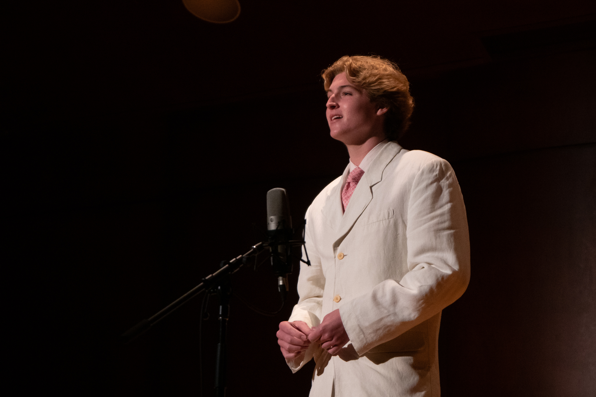 A young man performing in a student vocal concert.