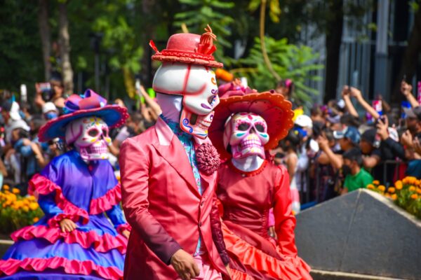 A Dia de los Muertos parade featuring skeletons in vibrant costumes.
