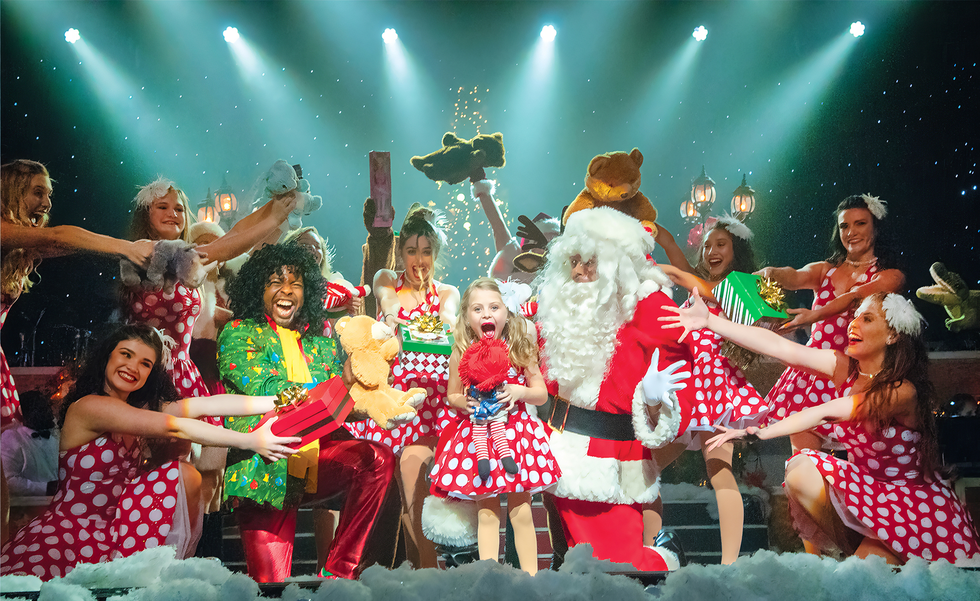 A Christmas performance with Santa, a young girl with a doll, and a costumed chorus holding gifts.