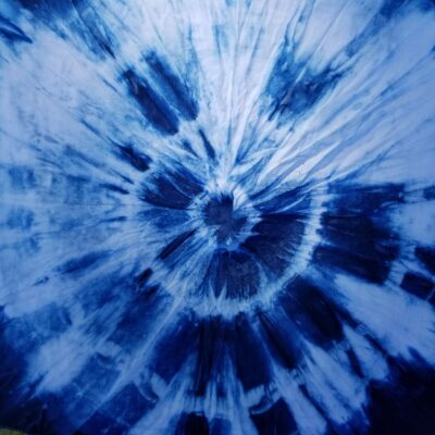 Indigo in a tie dye pattern forming concentric circles with color radiating from the center.