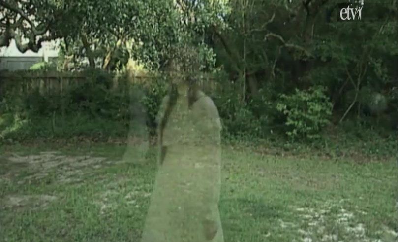 Two transparent ghostly figures, both female, in a grassy yard with bushes, trees, and a fence.