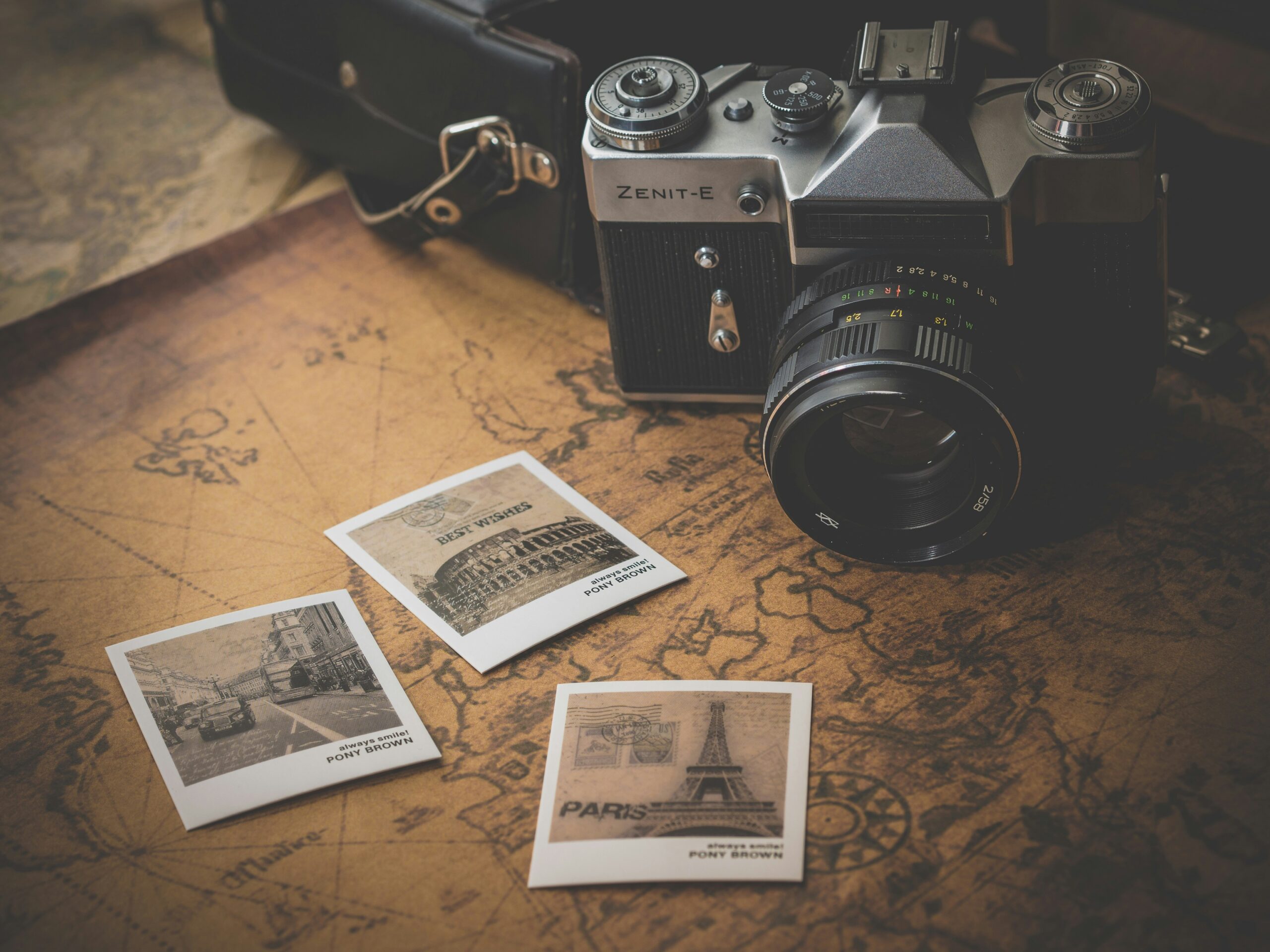 A DSLR camera and 3 Polaroid-style photographs, on a hand-drawn map.