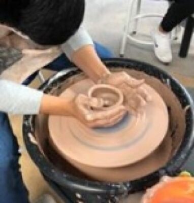 A person works on a pottery wheel.