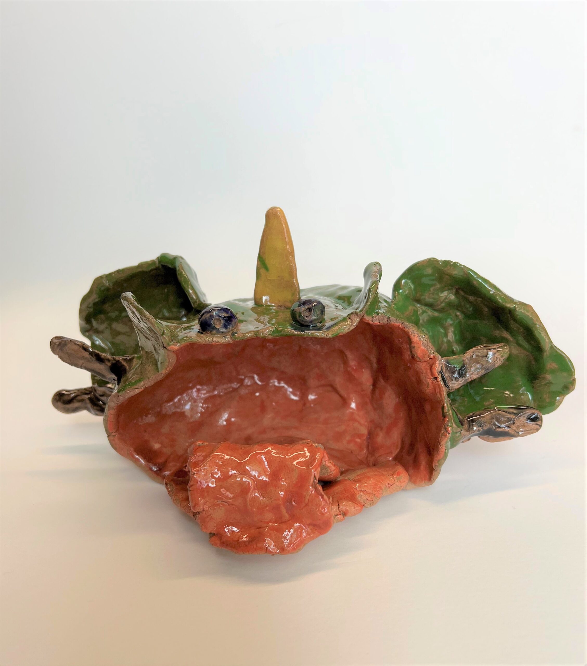 A child's ceramic sculpture of a sea monster with its mouth open.
