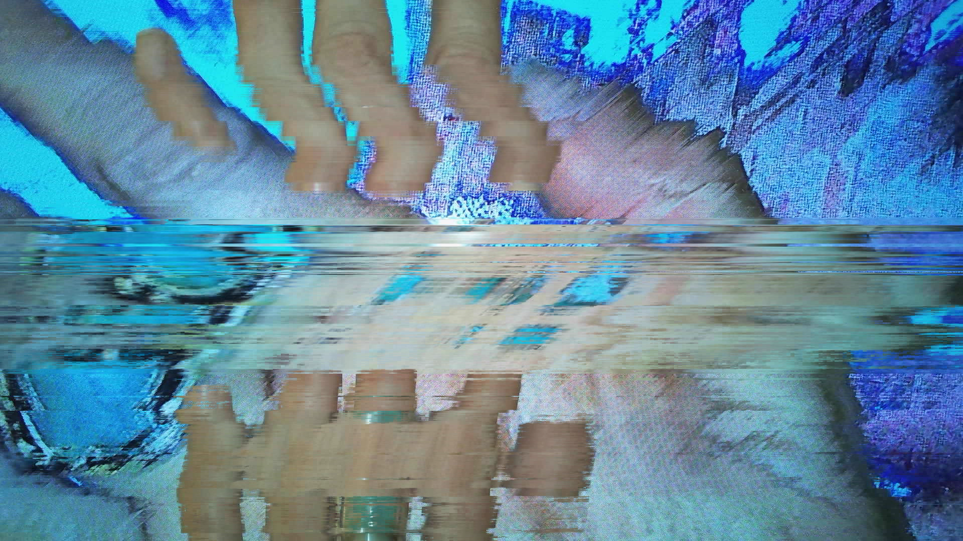 A digital "glitch" art image with a blue color palette and the appearance of hands.