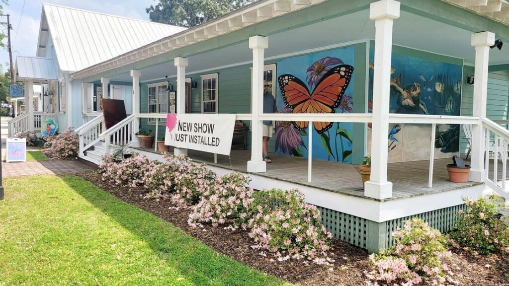 The porch of the SOBA Gallery with a butterfly mural on a sunny day.