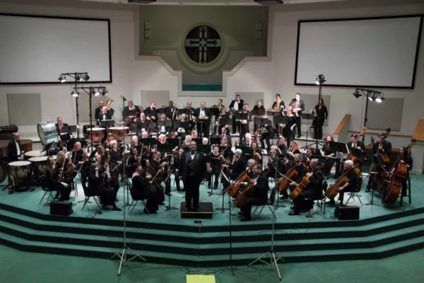 A 60-piece orchestra on a church stage.