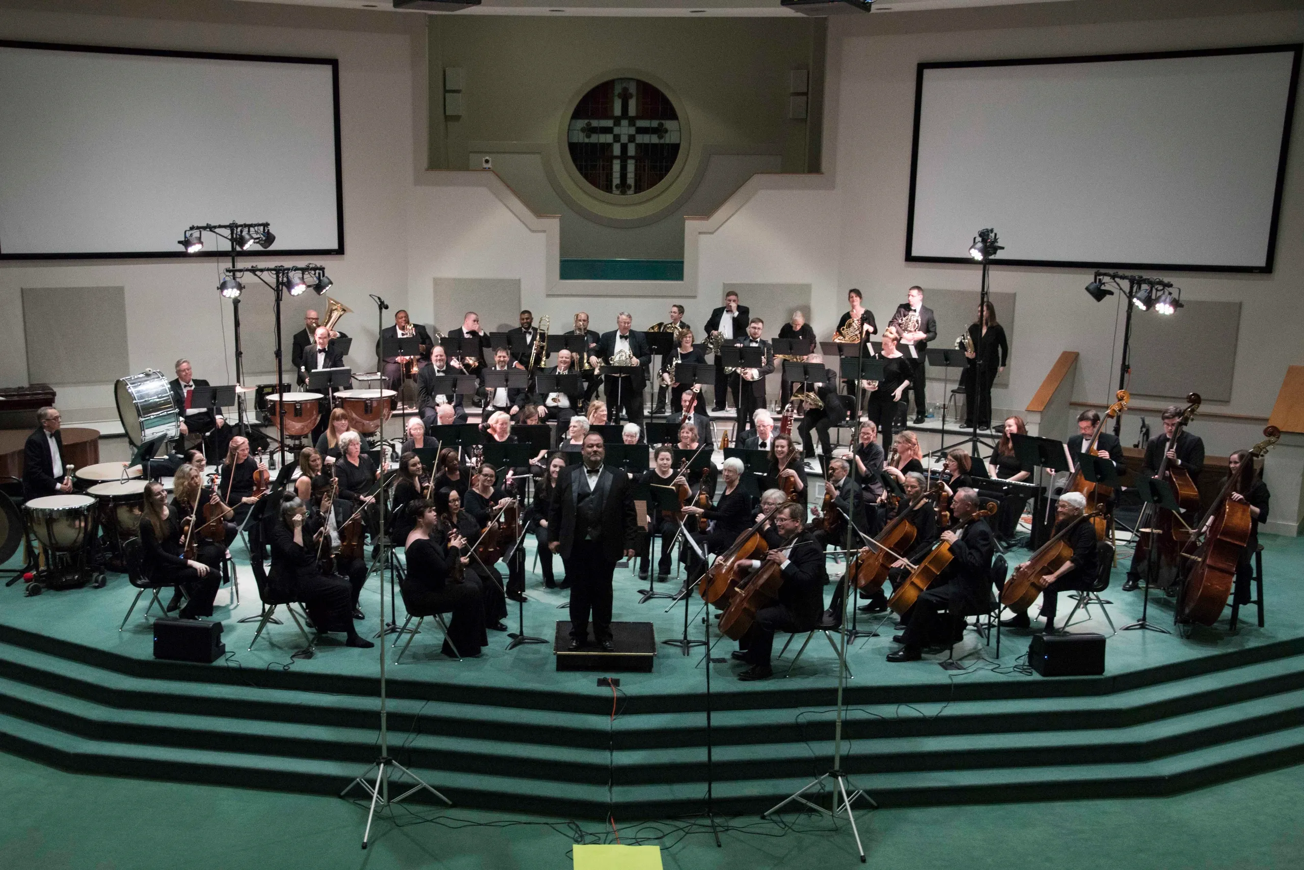 A 60-piece orchestra on a church stage.