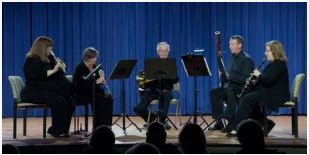 A woodwind quintet (3 women and 2 men) plays onstage.