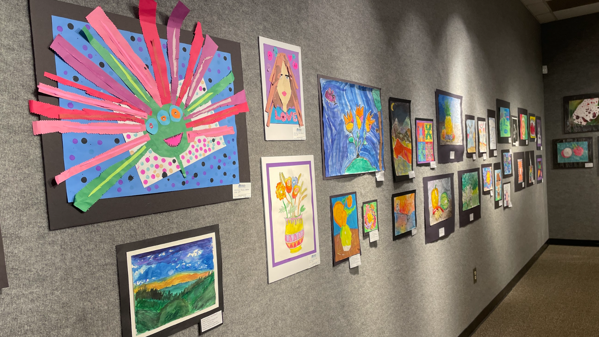 Children's artwork on a gallery wall