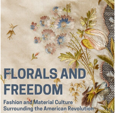 Needlework depicting pink, blue, brown, and white flowers on green stems with green leaves.
