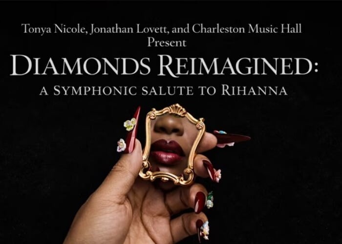 A Black woman's hand holds a miniature mirror reflecting her nose and red lips.