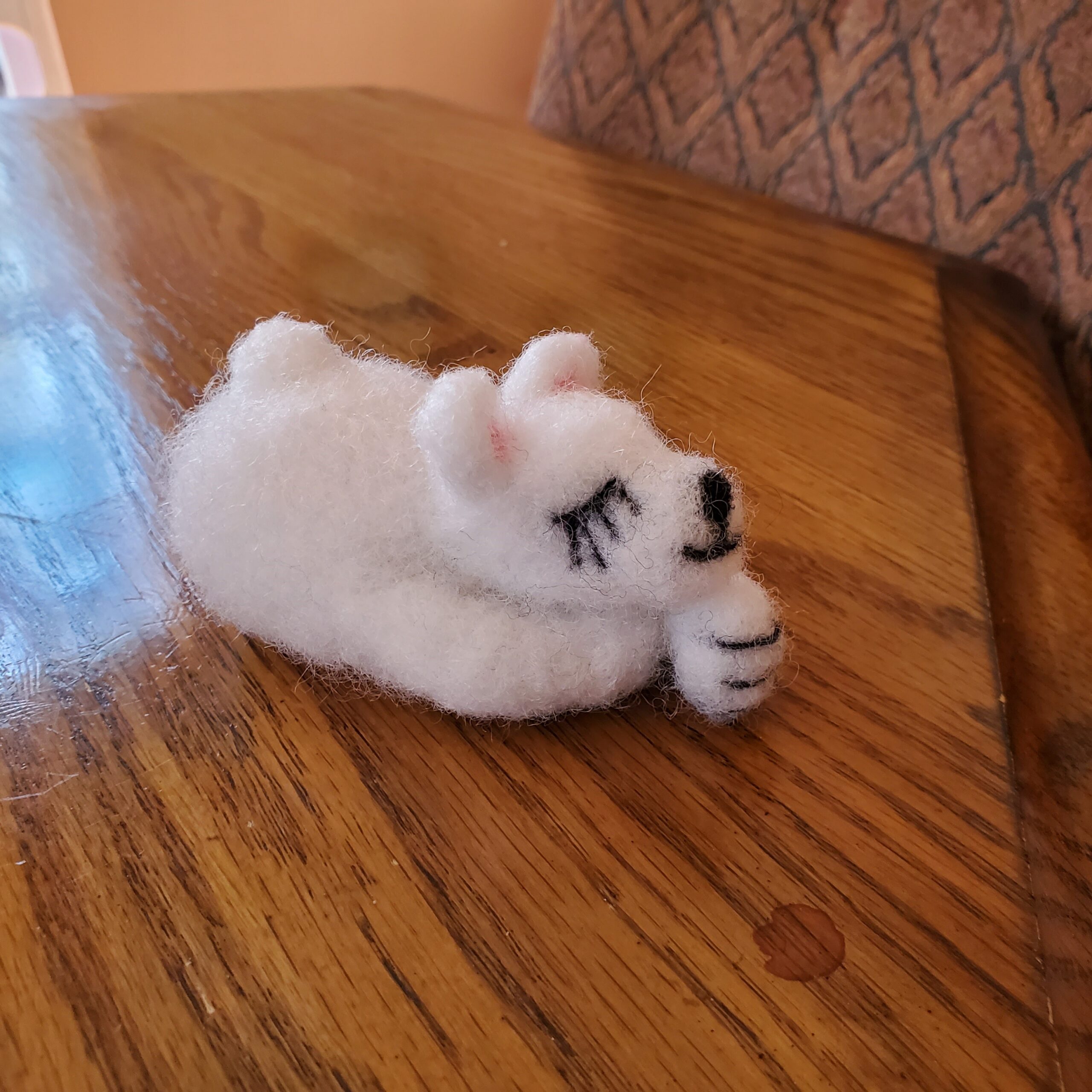 A small polar bear constructed of felt.