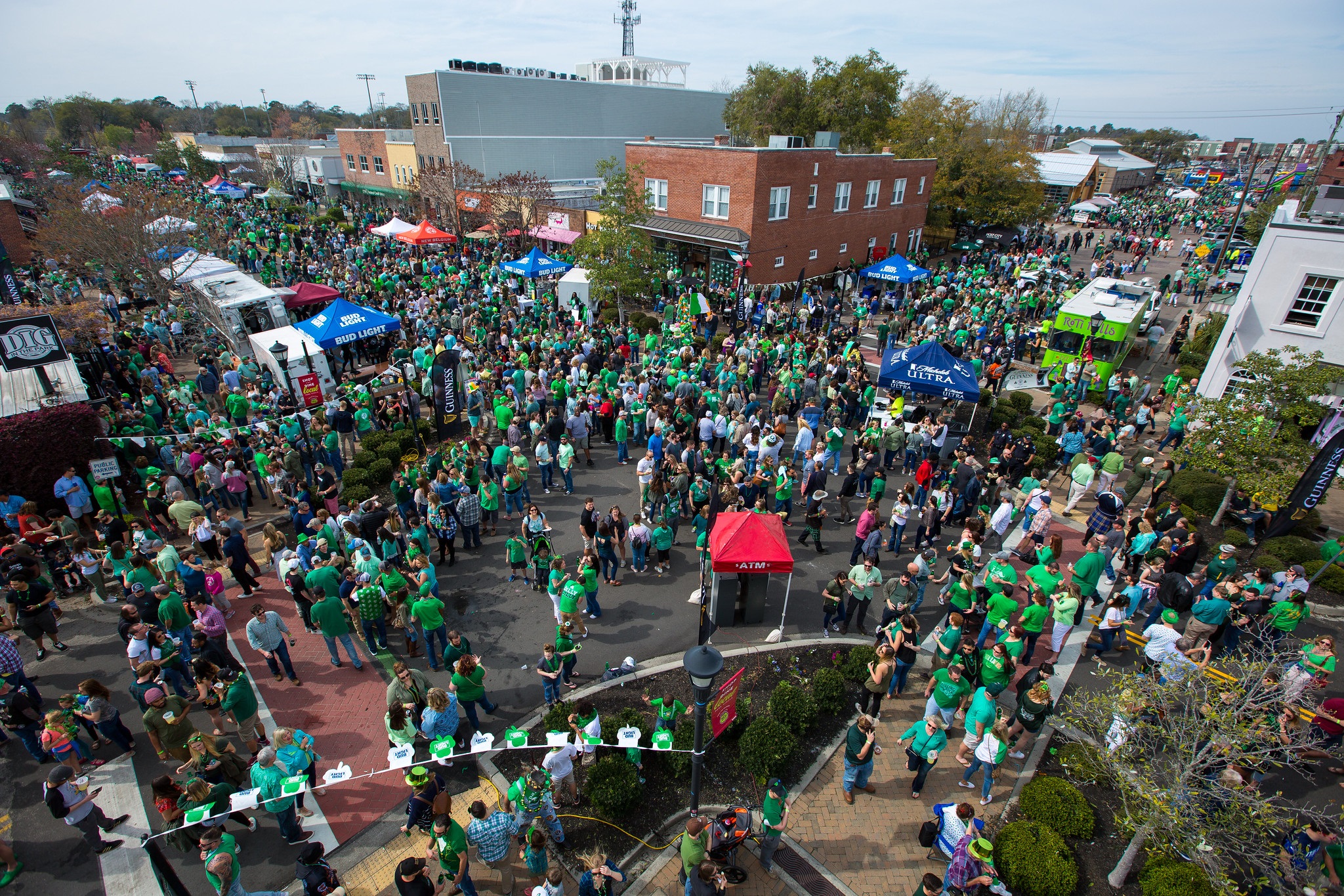 Overhead photo of a crowd attending a street festival. Most are dressed in green.