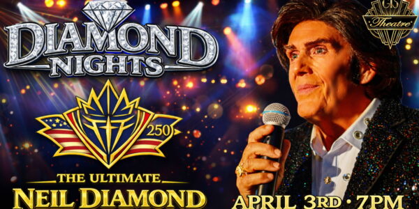 Singer dressed as Neil Diamond performs with a microphone with stage lights in the background.