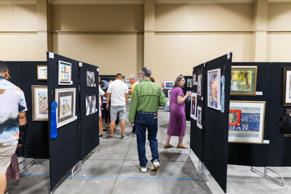 A small group of people browsing a n indoor photography exhibition.