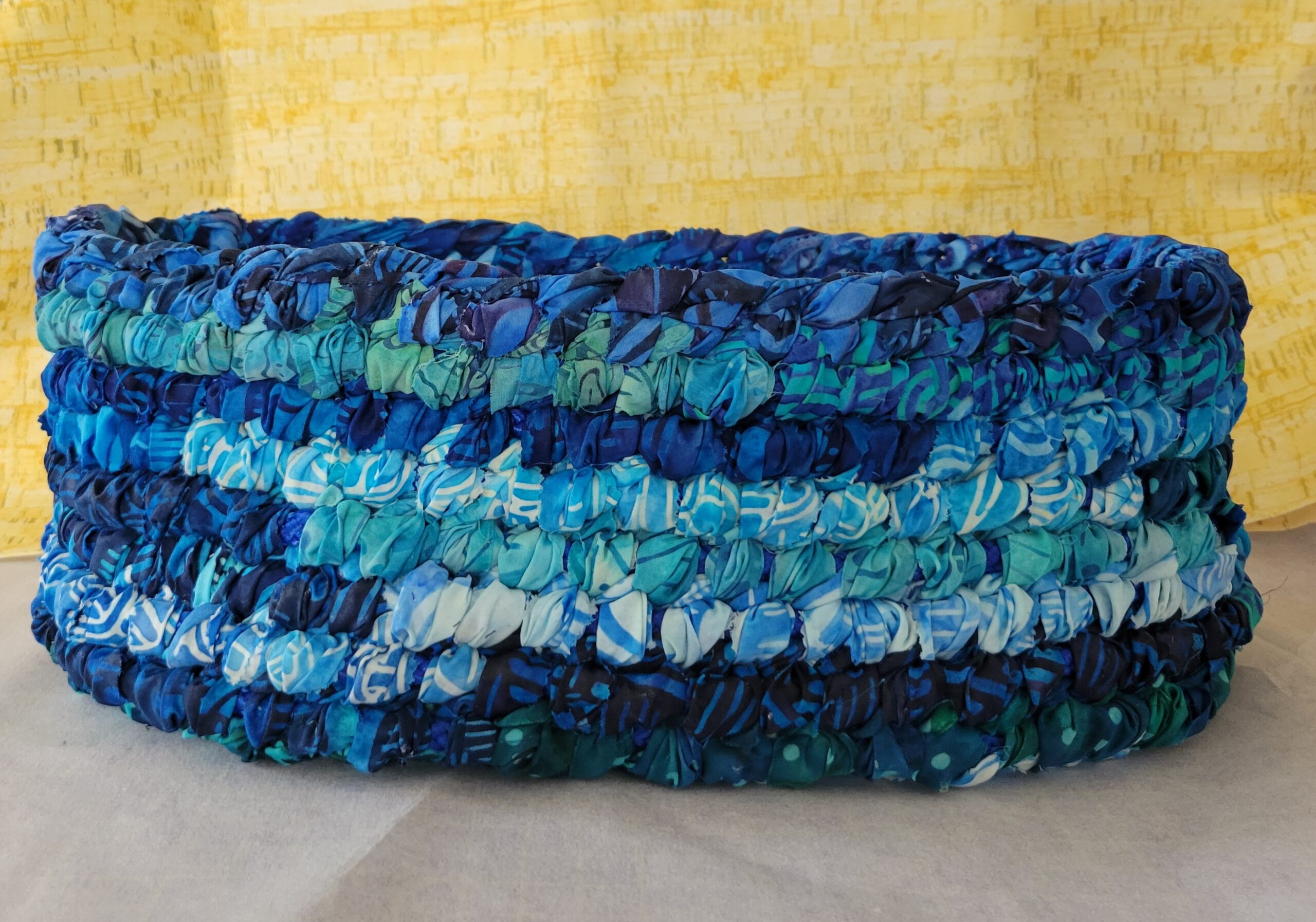 A 8-layer basket woven of blue cloths in a range of tones and patterns.