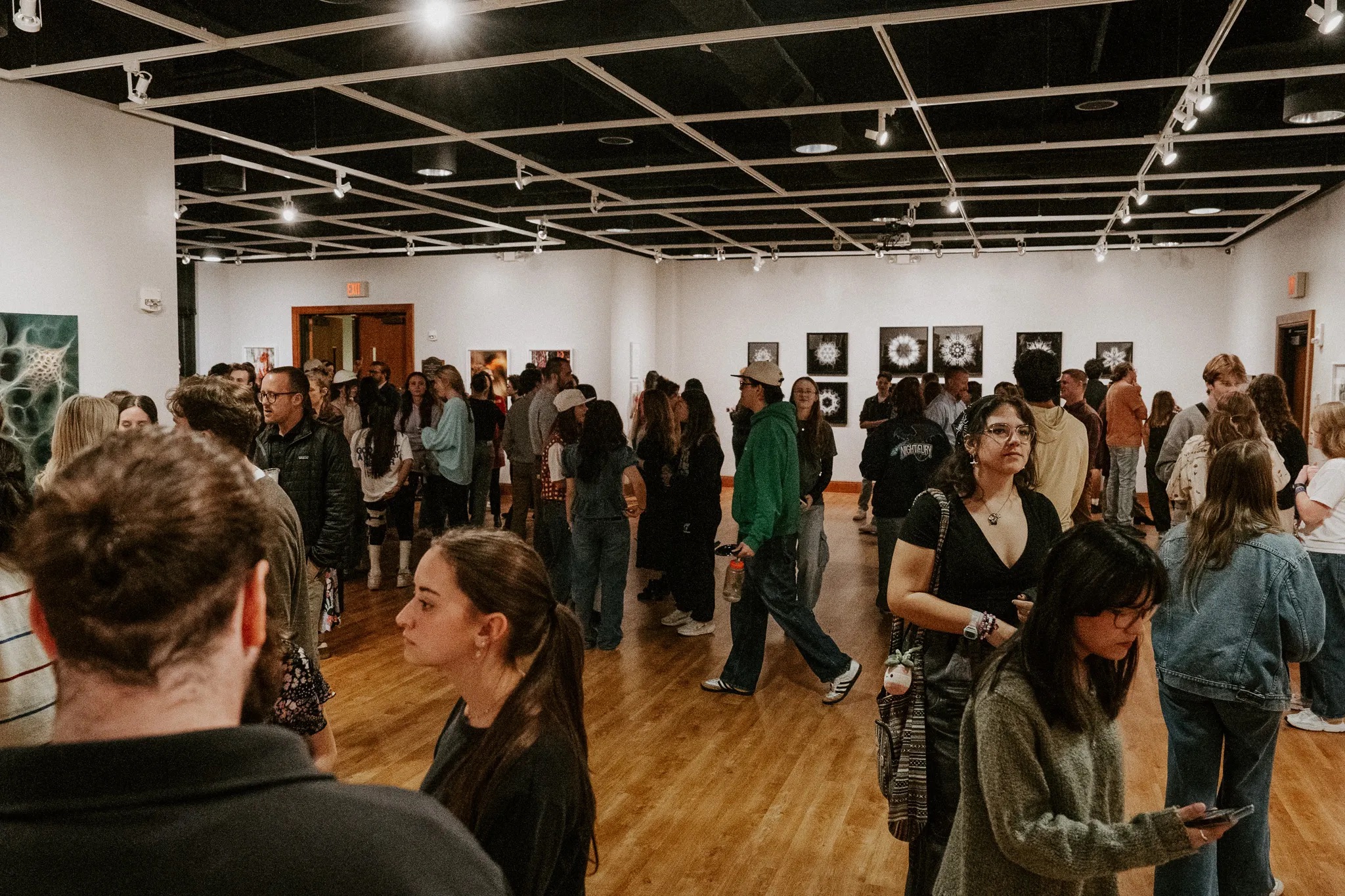 Students walking through a gallery during an exhibition reception.