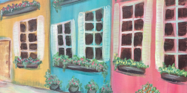 Painted row of house fronts in yellow, blue, and pink, with flowers in window boxes.