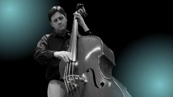 A man with dark hair plays upright bass with his eyes closed.