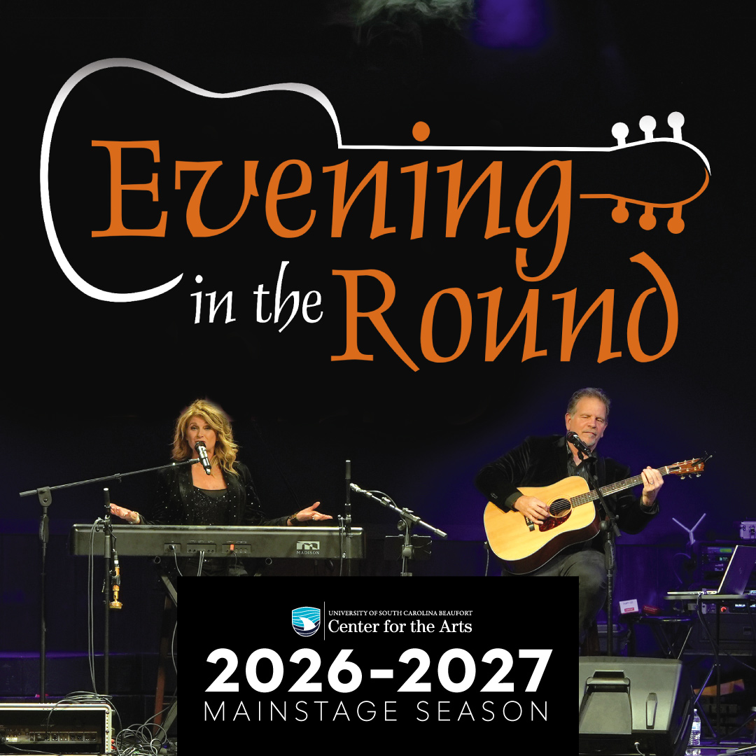 Onstage, a woman at a keyboard and a man with a guitar are behind microphones.