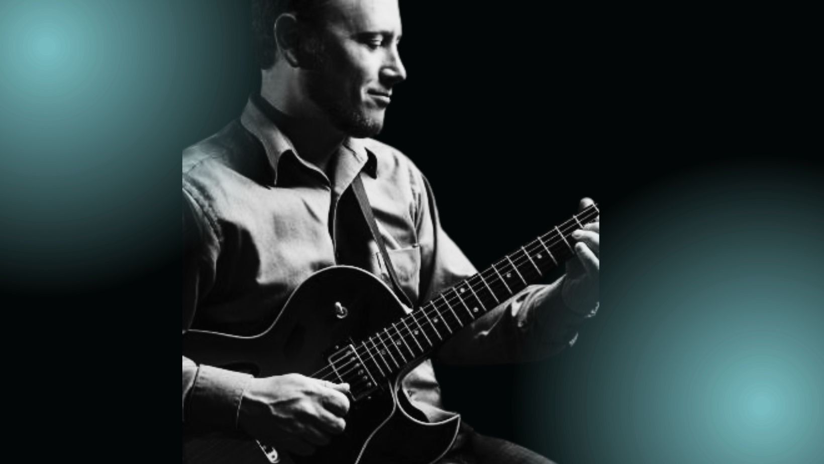 A man plays guitar in profile. He is smiling slightly.