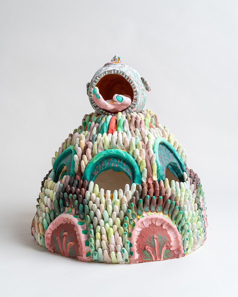 Ceramic dome with finger-like projections, cutaway arches, and a sphere with a hand reaching out.