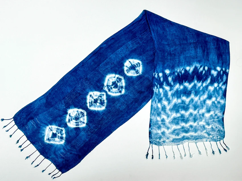 Indigo scarf in bright blue with white patterns and tassels.