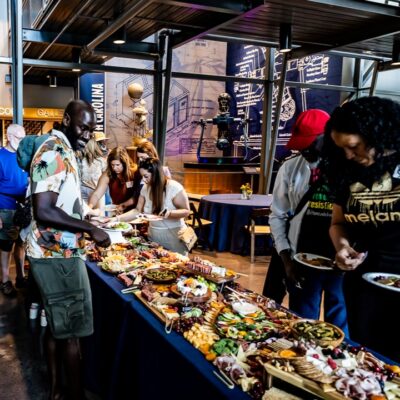 Event participants at a buffet table of reception food.