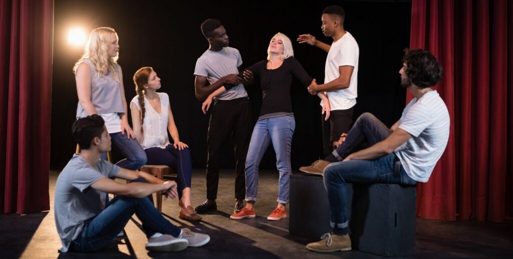 Actors rehearse a play in street clothes on a stage