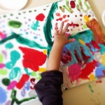 A child participates in a Painting Table activity